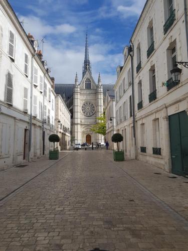 a large building with a clock tower in a street at Appartement 2 chambres cosy centre ville historique in Orléans