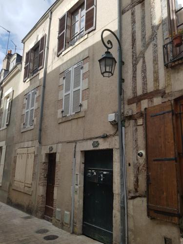a street light next to a building with a door at Appartement 2 chambres cosy centre ville historique in Orléans