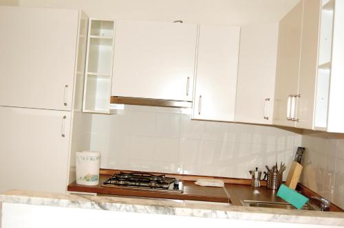 Villa FaraldiAgriturismo LE GOCCE的带白色橱柜和水槽的白色厨房