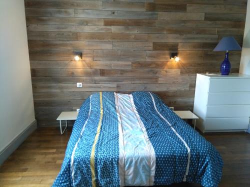 クソンリュプト・ロンジュメールにあるAppartement Xonrupt 6 personnesの木製の壁のベッドルーム1室、ベッド1台、テーブル2台が備わります。