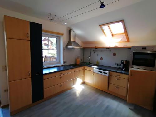 eine große Küche mit Holzschränken und einem Fenster in der Unterkunft Haus Tressenstein in Bad Aussee