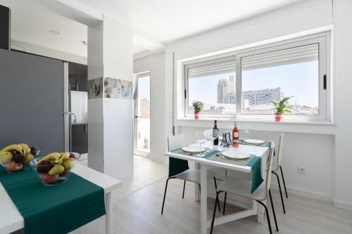 a kitchen and dining room with a white table and chairs at Moreira 284 in Porto