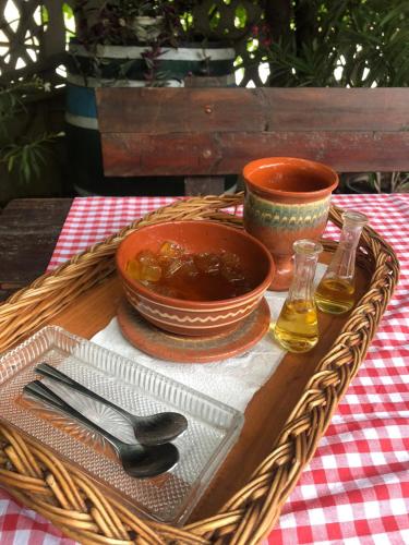 a wicker table with a bowl of food and a bowl of oil at Etno Apartmani ''Vlaška kuća'' in Kladovo