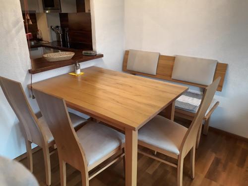 a wooden dining room table with four chairs at Seeappartment Regina Bodensdorf am Ossiacher See am Fuße der Gerlitzen in Tschöran