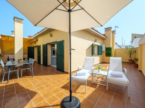 patio con tavolo, sedie e ombrellone di LA ALCAZABA - Exclusive Penthouse a Málaga