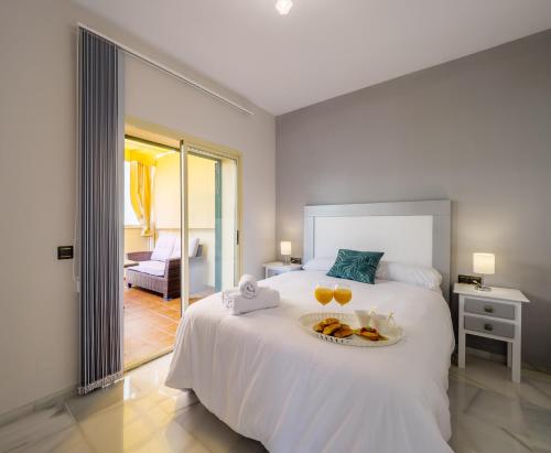 una camera da letto con un letto e un vassoio di cibo sopra di LA ALCAZABA - Exclusive Penthouse a Málaga