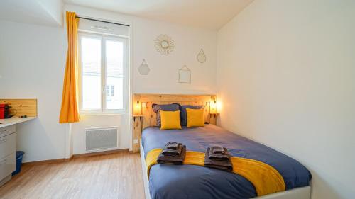 a bedroom with a large bed with yellow and blue sheets at Cosy Apparts Brive in Brive-la-Gaillarde