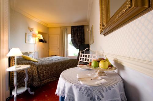 a room with two beds and a table with a bowl of fruit at Il Sole Di Ranco in Ranco