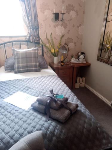 a bedroom with a bed with a stuffed animal on it at Autumn Leaves Guest House in Windermere