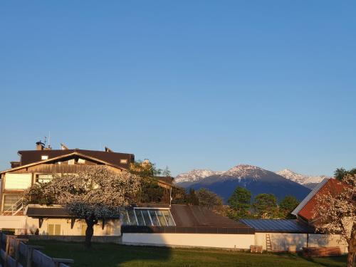a house with a mountain in the background at Alp Art Hotel Götzens in Innsbruck