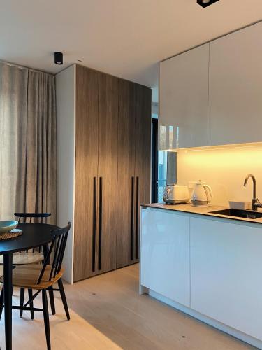 a kitchen and dining room with a table and cabinets at Apartment KORA in Pervalka