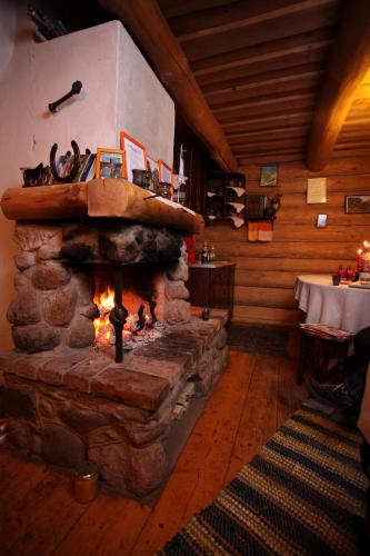 a stone fireplace in a room with a table at Zirgu sēta "Klajumi" - Horse ranch "Klajumi" in Kaplava