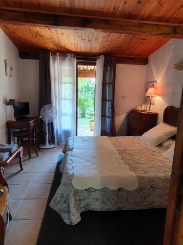 1 dormitorio con cama, escritorio y ventana en Chambres d'hôtes La Chabrière, en Cliousclat
