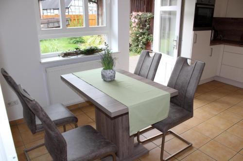 a dining room table with chairs and a vase on it at Ferienwohnung Mühlendamm in Bergen