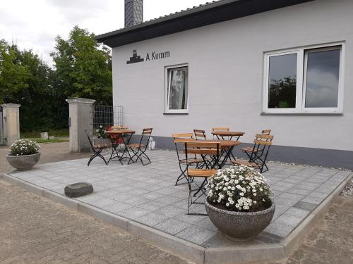 a patio with tables and chairs in front of a building at Pension Zum Stein in Hohenkirchen