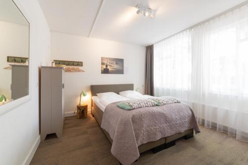 Schlafzimmer mit einem Bett und einem Fenster in der Unterkunft Het Vlielandhotel in Oost-Vlieland