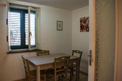 a dining room with a table and chairs and a window at Finisterrae in Procida