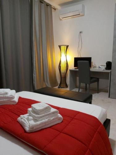 Schlafzimmer mit einem Bett mit einer roten Decke und einem Schreibtisch in der Unterkunft MATERA TO LOVE in Matera