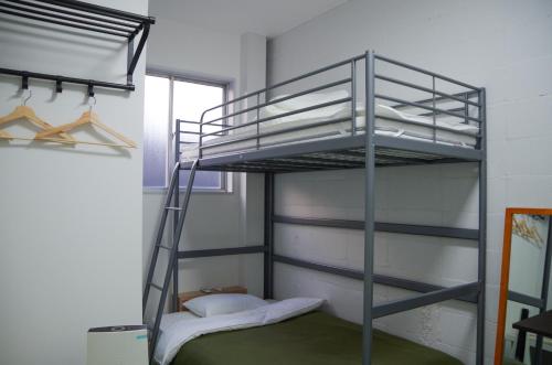 Ein Etagenbett oder Etagenbetten in einem Zimmer der Unterkunft Travelers' house ROOTs