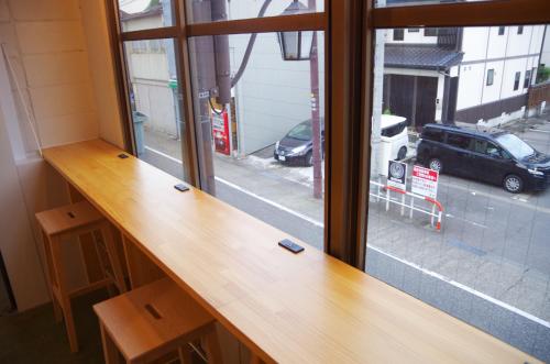 a wooden counter in a room with a window at Travelers' house ROOTs in Takaoka