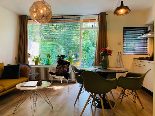 uma sala de estar com um sofá, uma mesa e cadeiras em Zonnebos, private garden, fresh air, relax! em Otterlo