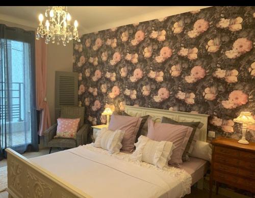 1 dormitorio con 1 cama con pared de flores en Villa Raissa marché Arago et les plages en Les Sables-dʼOlonne