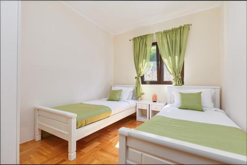 twee bedden in een kamer met groen en wit bij Kotor Sunset Apartments in Kotor