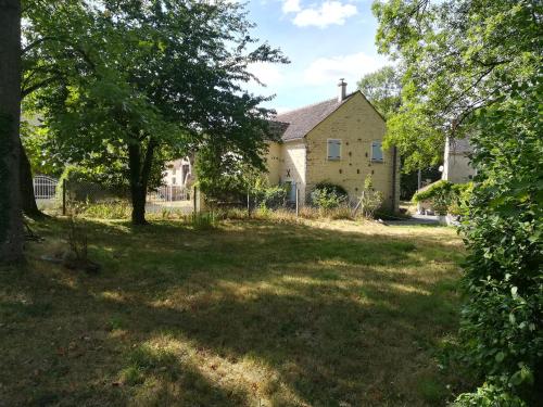 a house in the middle of a yard with trees at Les Coucous in Augerville-la-Rivière