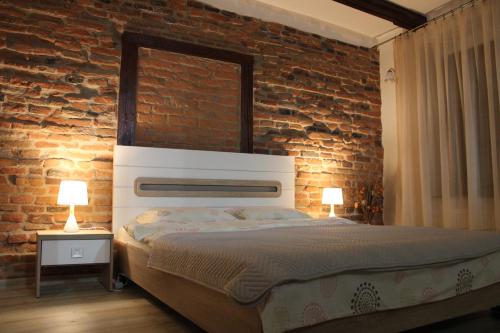 錫比烏的住宿－MSH Rustic apartment - Liars Bridge Sibiu，一间卧室设有一张床和砖墙