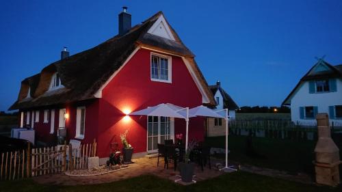 a red house with an umbrella in front of it at Haus Elve in Zierow