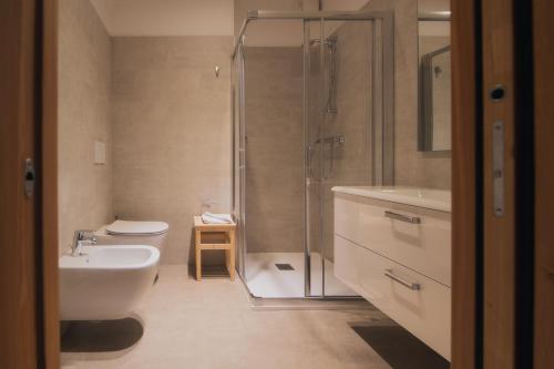 a bathroom with a shower and a sink and a toilet at Dolomiti Hotel Cozzio in Madonna di Campiglio