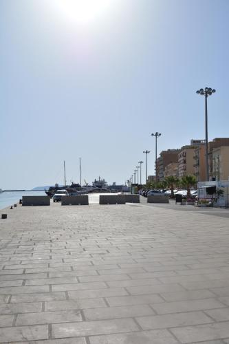 a large parking lot with benches and the water at AL CIVICO 1 APARTMENTS in Trapani