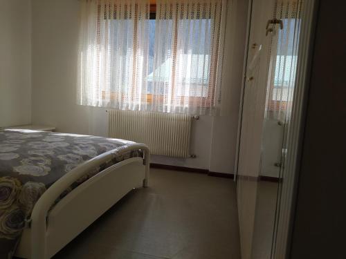 1 dormitorio con 1 cama y 2 ventanas grandes en Siora Lina Appartamenti, en Vigo di Cadore