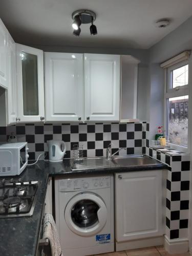 a kitchen with a washing machine and a sink at Hanwell House in Liverpool