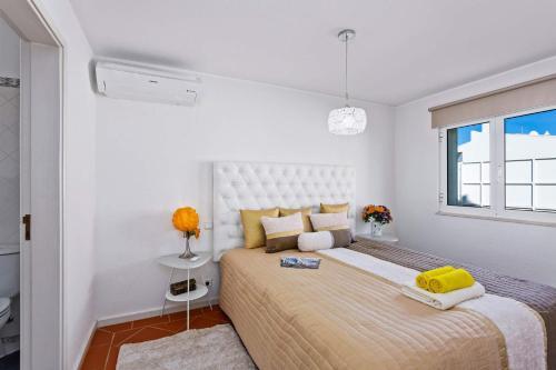 um quarto com uma cama grande e uma janela em Villa Maresia Dourada em Guia