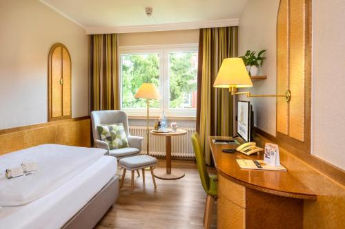 バート・ベヴェンセンにあるAkzent Hotel Berlinのベッド、デスク、椅子が備わるホテルルームです。