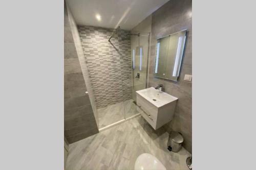 y baño con lavabo blanco y ducha. en LUX 1BD/1BA City Center Apartment, en Blagoevgrad