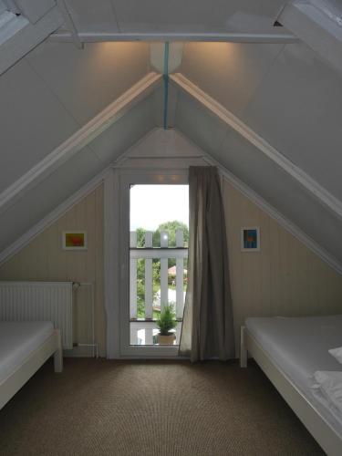 a attic room with two beds and a window at Sonja House Abertamy in Abertamy