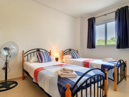 Habitación con 2 camas individuales y ventilador. en Hacienda Golf Resort - 8408, en Sucina