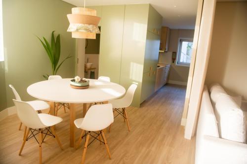 a small kitchen and dining room with a white table and chairs at Ar d'Sal - Praia de Angeiras - Beach&GoodFood in Lavra