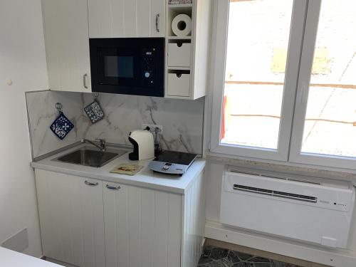 a small kitchen with a sink and a microwave at Indipendent Blue in Ferrara