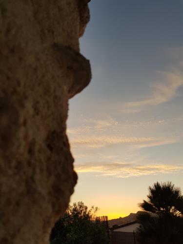 a view of the sunset through a rock at Casa Vacanze Brezza di Gaffe in Torre di Gaffe