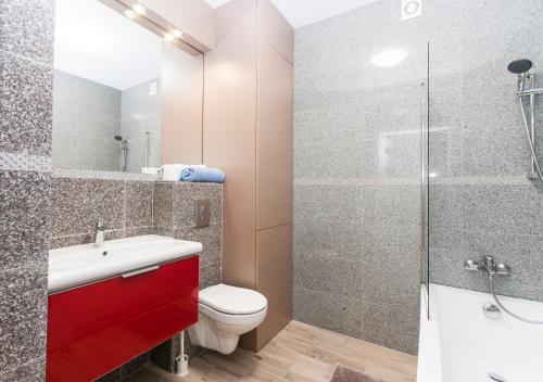 a bathroom with a toilet sink and a shower at Lesna Dreams Apartament in Pobierowo