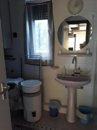 y baño con lavabo, aseo y espejo. en Retrovilla, en Balatonkenese