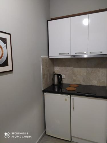 a kitchen with white cabinets and a black counter top at Brb rooms in Himare