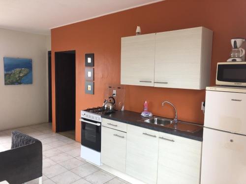 a kitchen with white cabinets and a sink and a microwave at Advantage Apartments Curacao in Willemstad