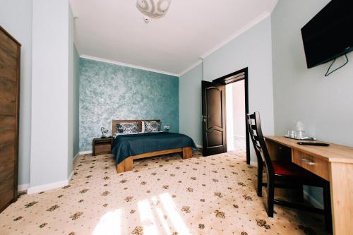a bedroom with a bed and a desk and a computer at Agropensiunea Ozon in Piatra Neamţ