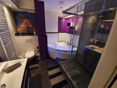 a bathroom with a walk in shower and a tub at SinueSsa in Cologne