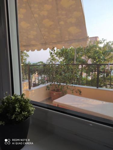 a window with a view of a balcony with plants at Brb rooms in Himare
