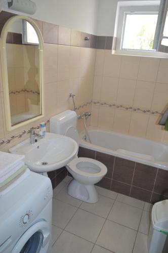 a bathroom with a sink and a toilet and a tub at Goga Apartments in Primošten